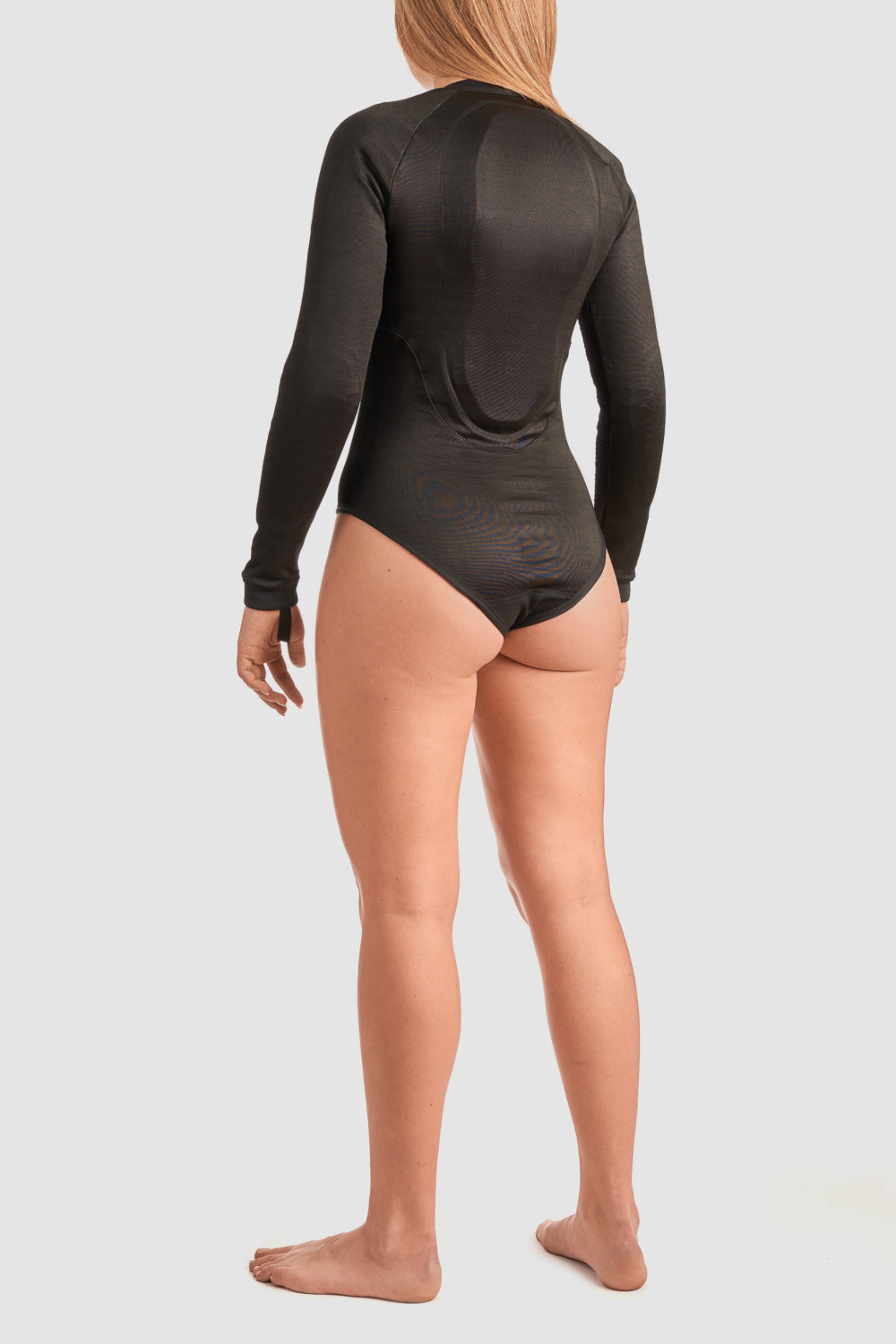 a back of a woman wearing black body suit base layer for women from Pando