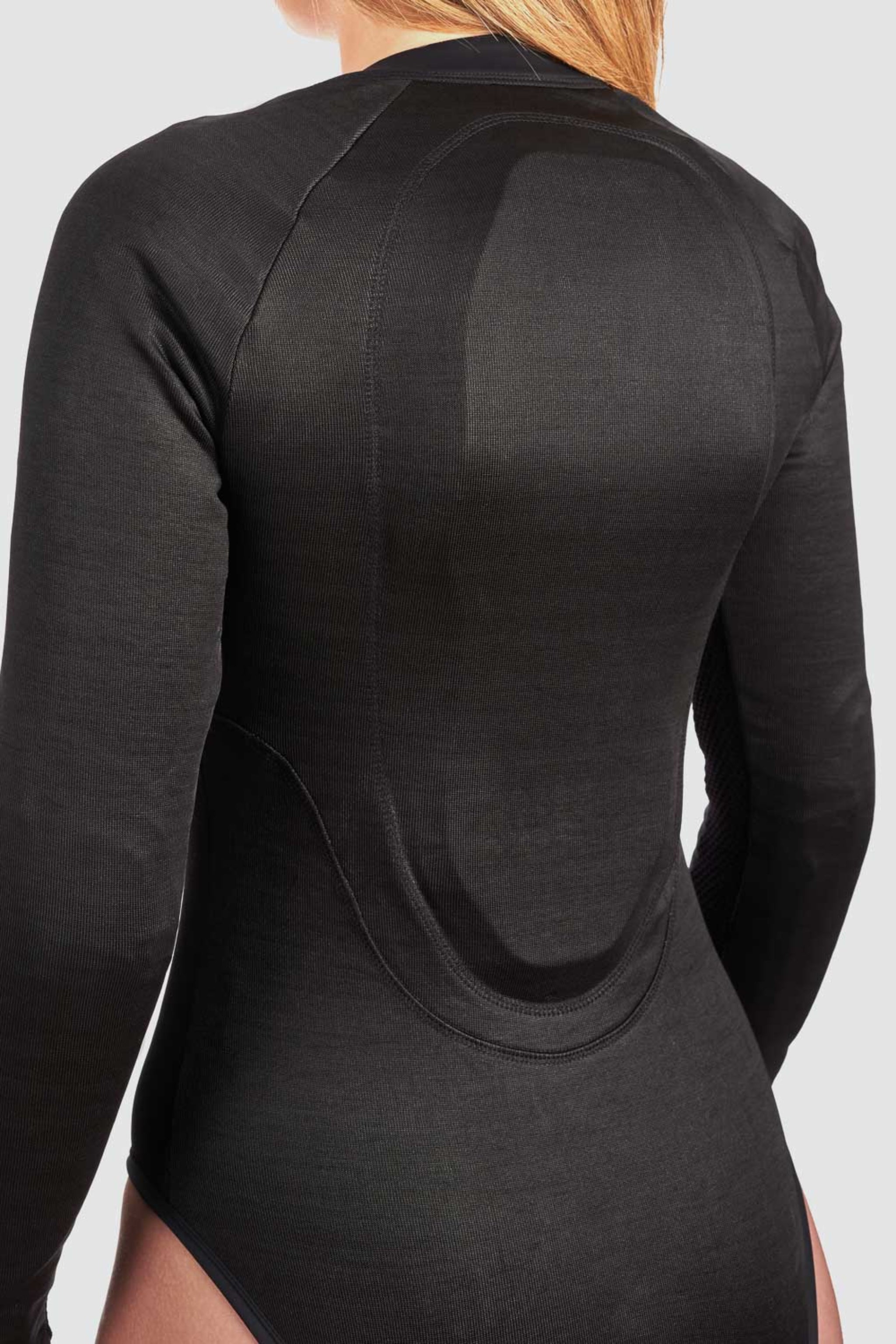 a back of a woman wearing black body suit base layer for women from Pando and a back protector