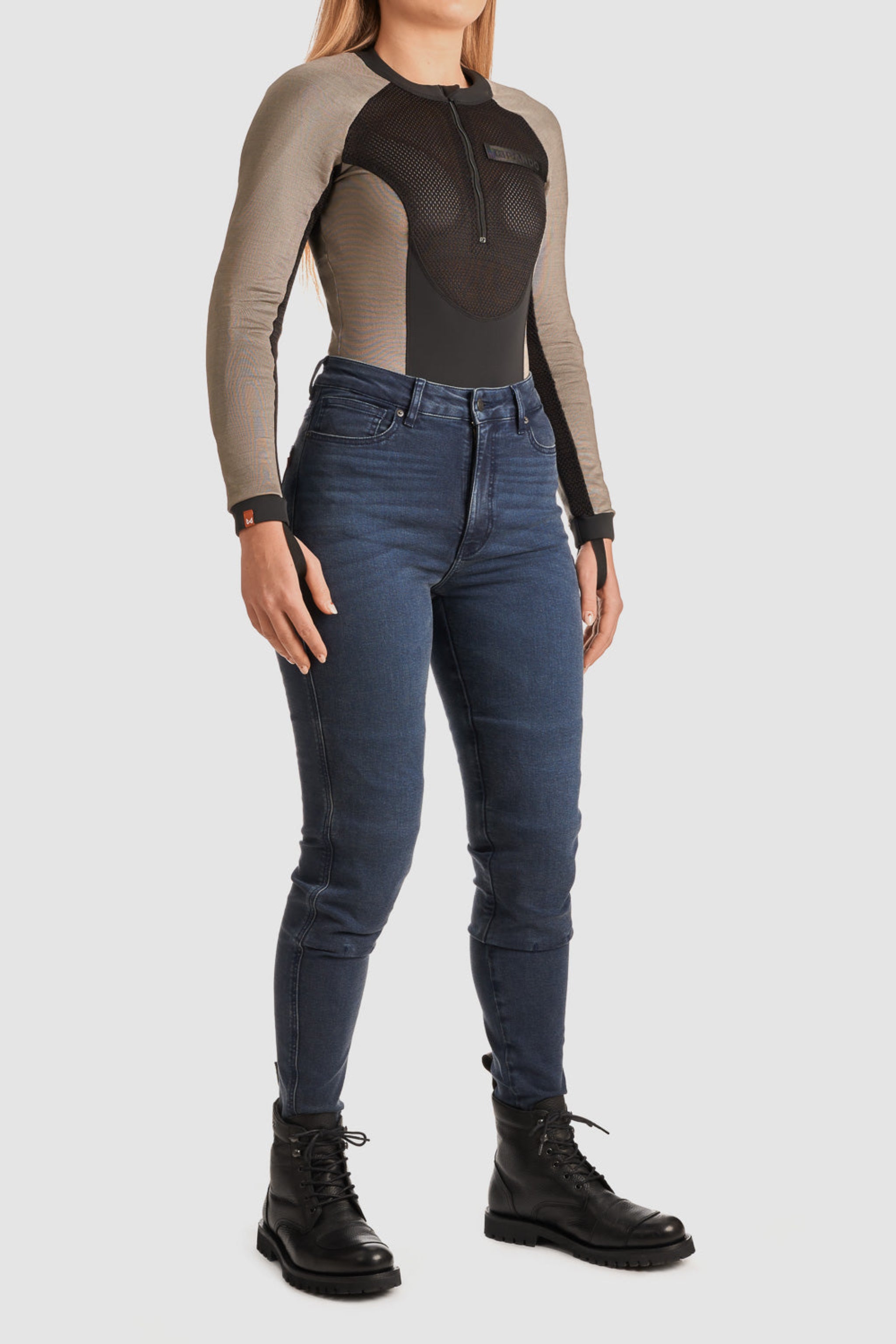 woman wearing Black and grey moto bodysuit with Pando logo and blue jeans
