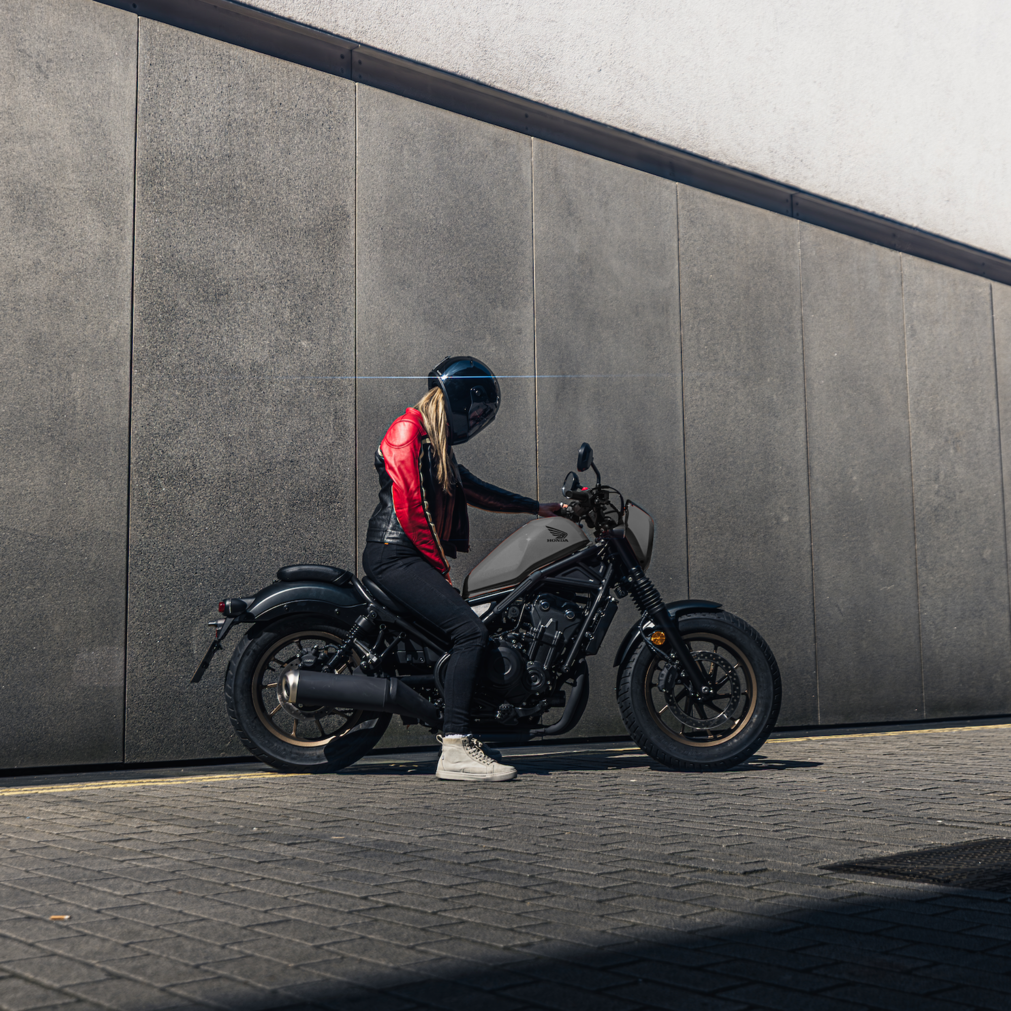 young woman motorcyclists in black red leather jacket