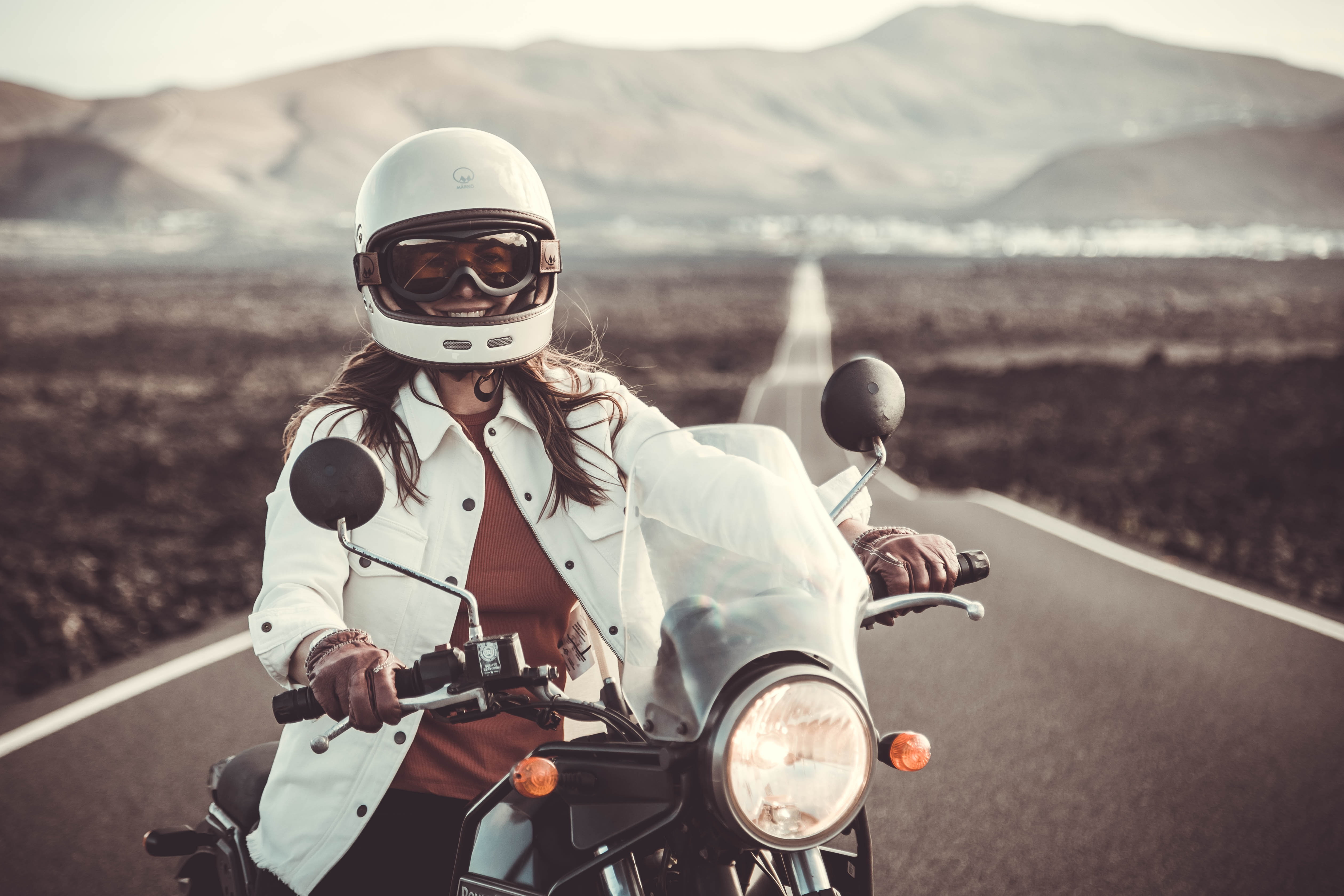 a woman with white hemet on her motorcycle wearing white denim mc shirt