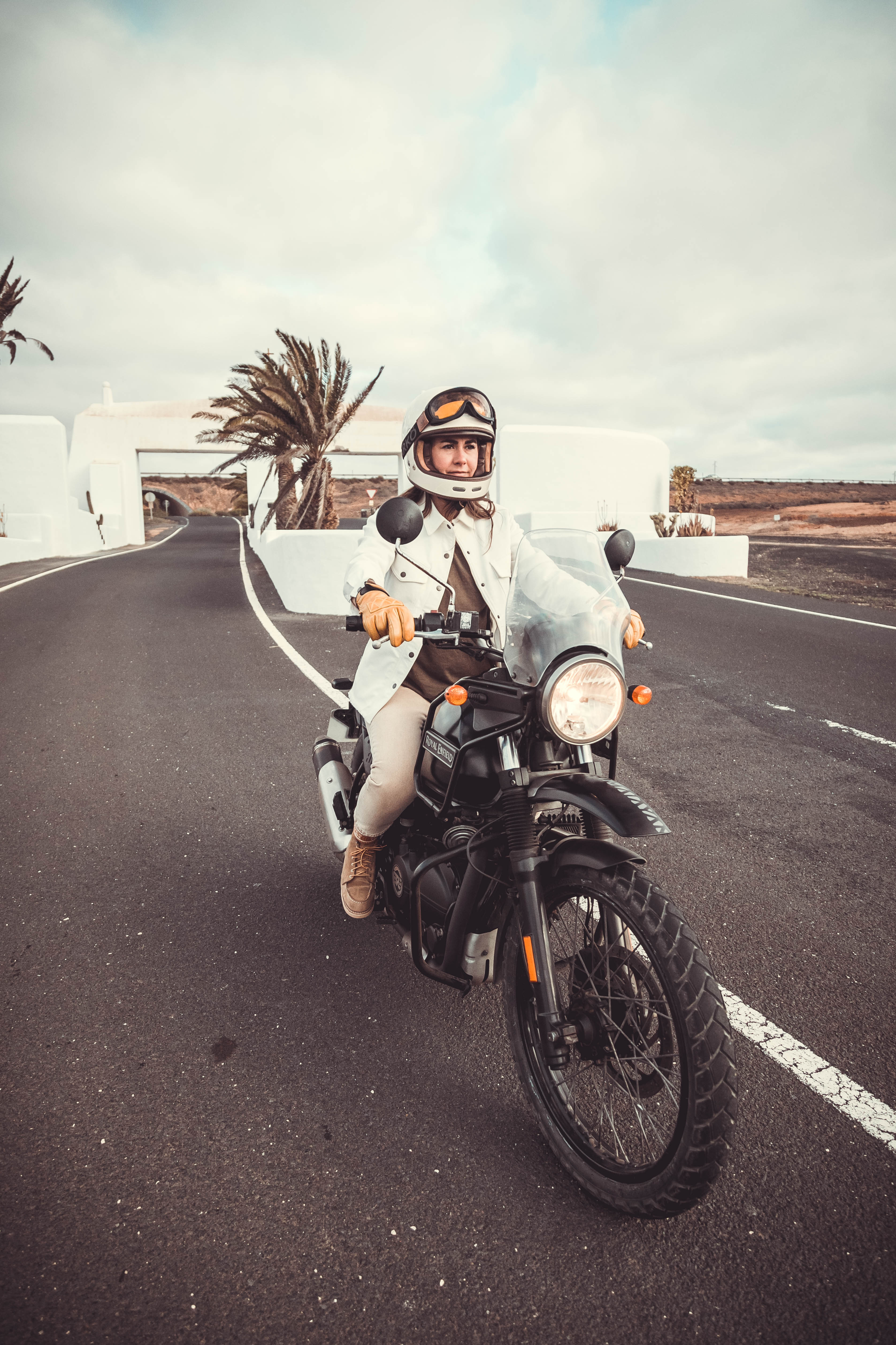 a woman with white hemet on her motorcycle wearing white denim mc shirt