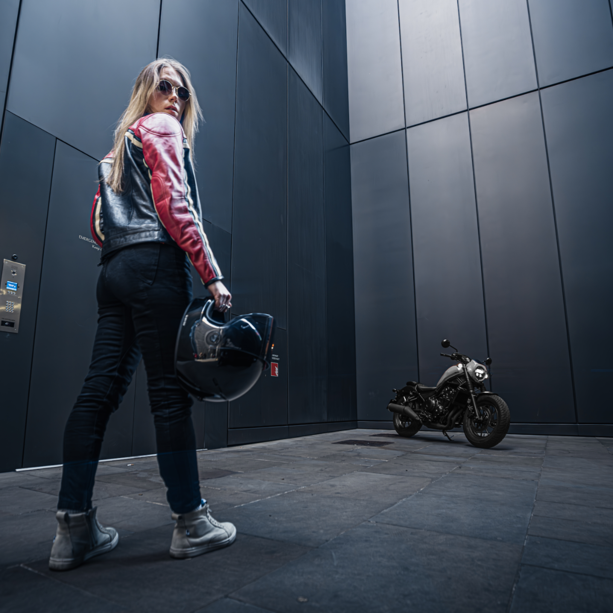young woman motorcyclists in black red leather jacket