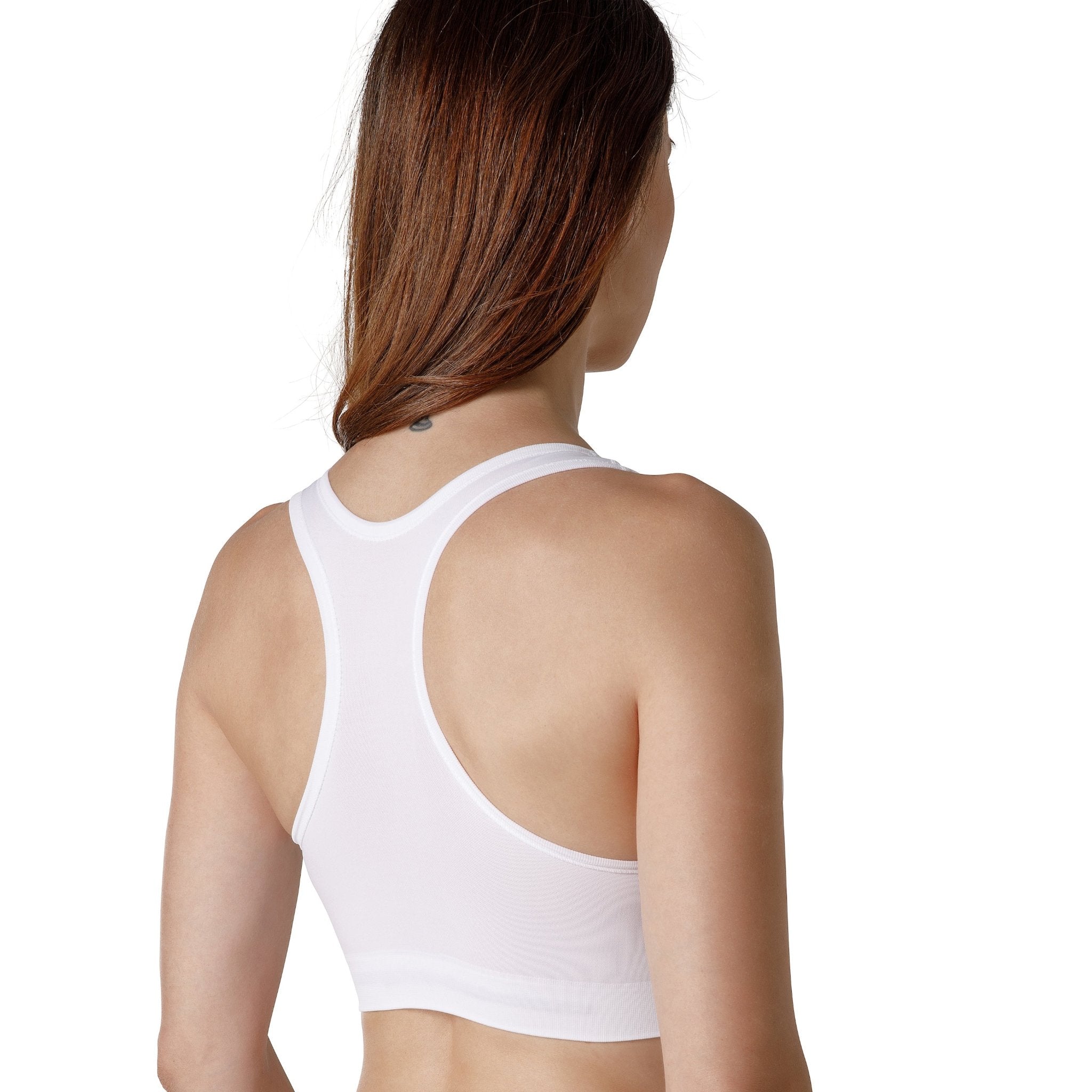 The back of a dark-haired woman wearing a white sport bra with wide straps from Tremonte.