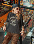 a young woman by game machines wearing off-black wide cut short sleeve women's motorcycle t-shirt with helmet motive and Fragile like a bomb logo