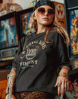 a young woman by game machines wearing off-black wide cut short sleeve women's motorcycle t-shirt with helmet motive and Fragile like a bomb logo