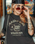 a young woman with sunglasses wearing off-black wide cut short sleeve women's motorcycle t-shirt with helmet motive and Fragile like a bomb logo