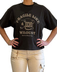 woman demonstarting a off-black wide cut short sleeve women's motorcycle t-shirt with helmet motive and Fragile like a bomb logo