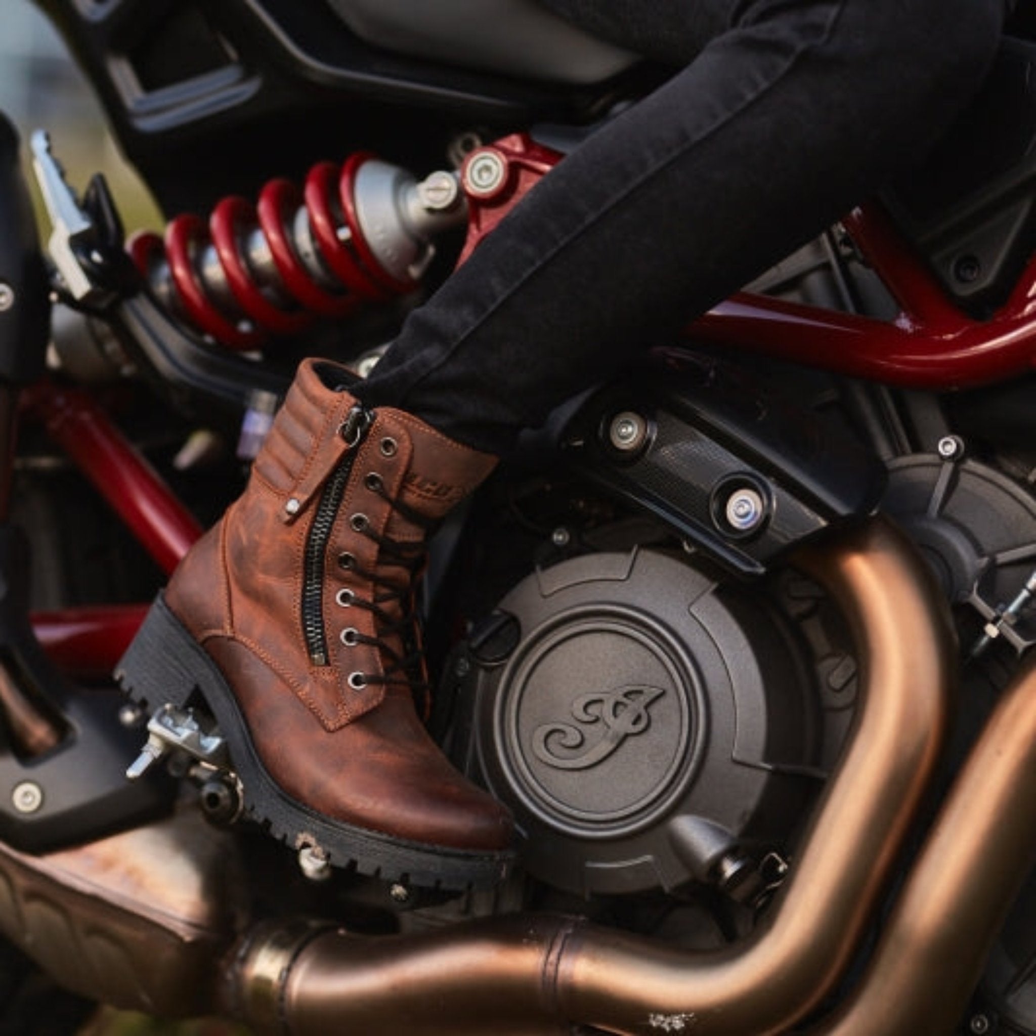 woman's foot on a motorcycle rest wearing brown leather mc boots