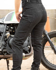 women's standing by a motorcycle legs wearing black mc jeans with high waist
