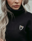 a blong young women wearing high neck black sweatshirt with motogirl logo in front