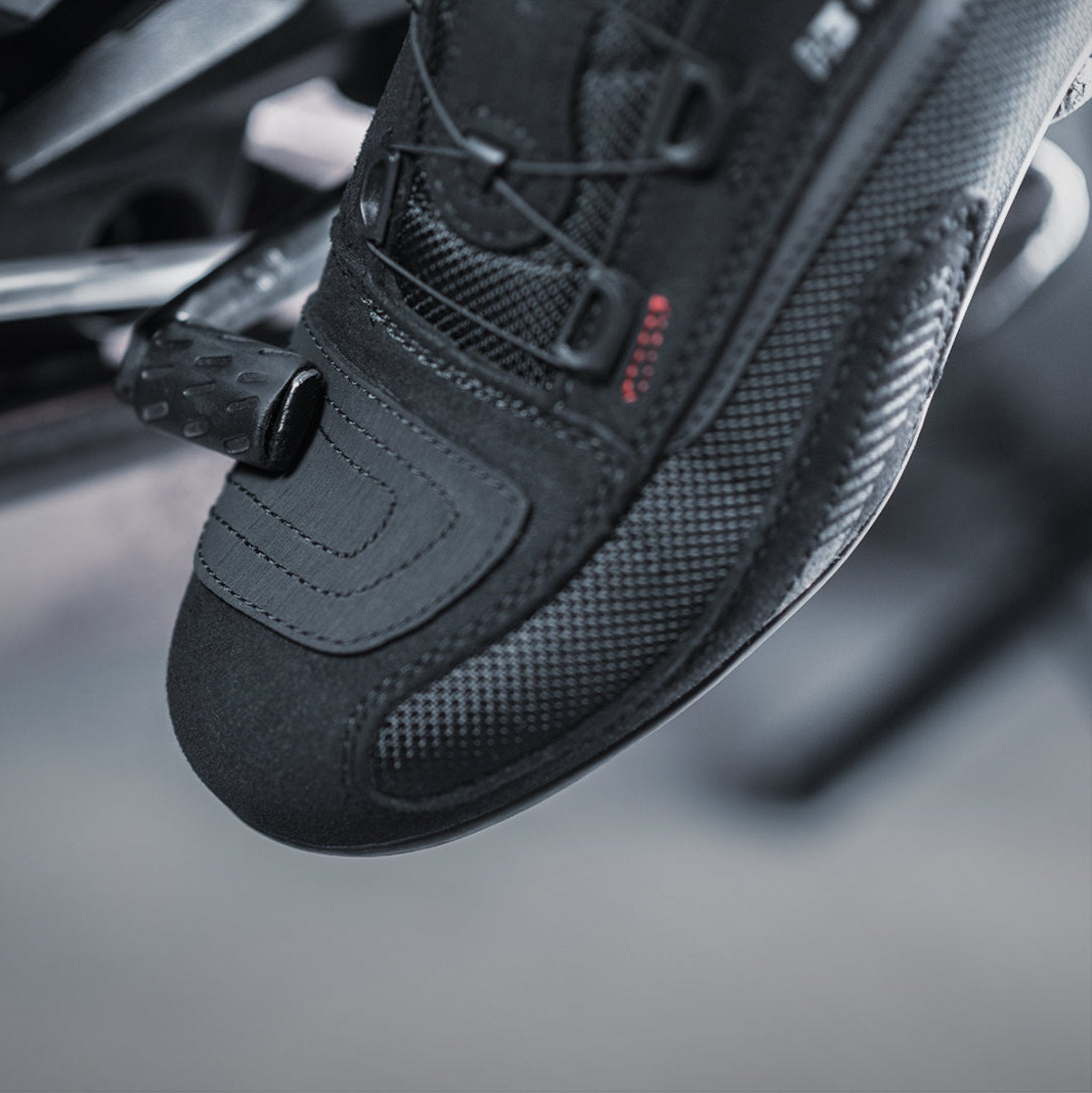 A feet changing motorcycle gear and wearing black and red female motorcycle sneakers from Shima