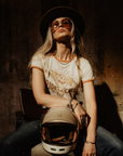 A woman with a hat and sunglasses wearing RIDE LIKE A GIRL retro style women's t-shirt from Wildust Sisters