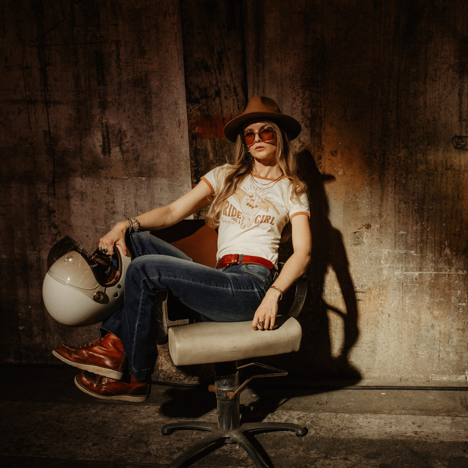 A woman sitting on a chair, wearing RIDE LIKE A GIRL retro style women&#39;s t-shirt from Wildust Sisters