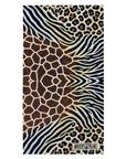 A rectangular beach towel featuring a multi-patterned design with giraffe spots, zebra stripes, and leopard print in brown, black, and beige. The brand name 'MOTO GIRL' is printed in a black box on the bottom right corner.