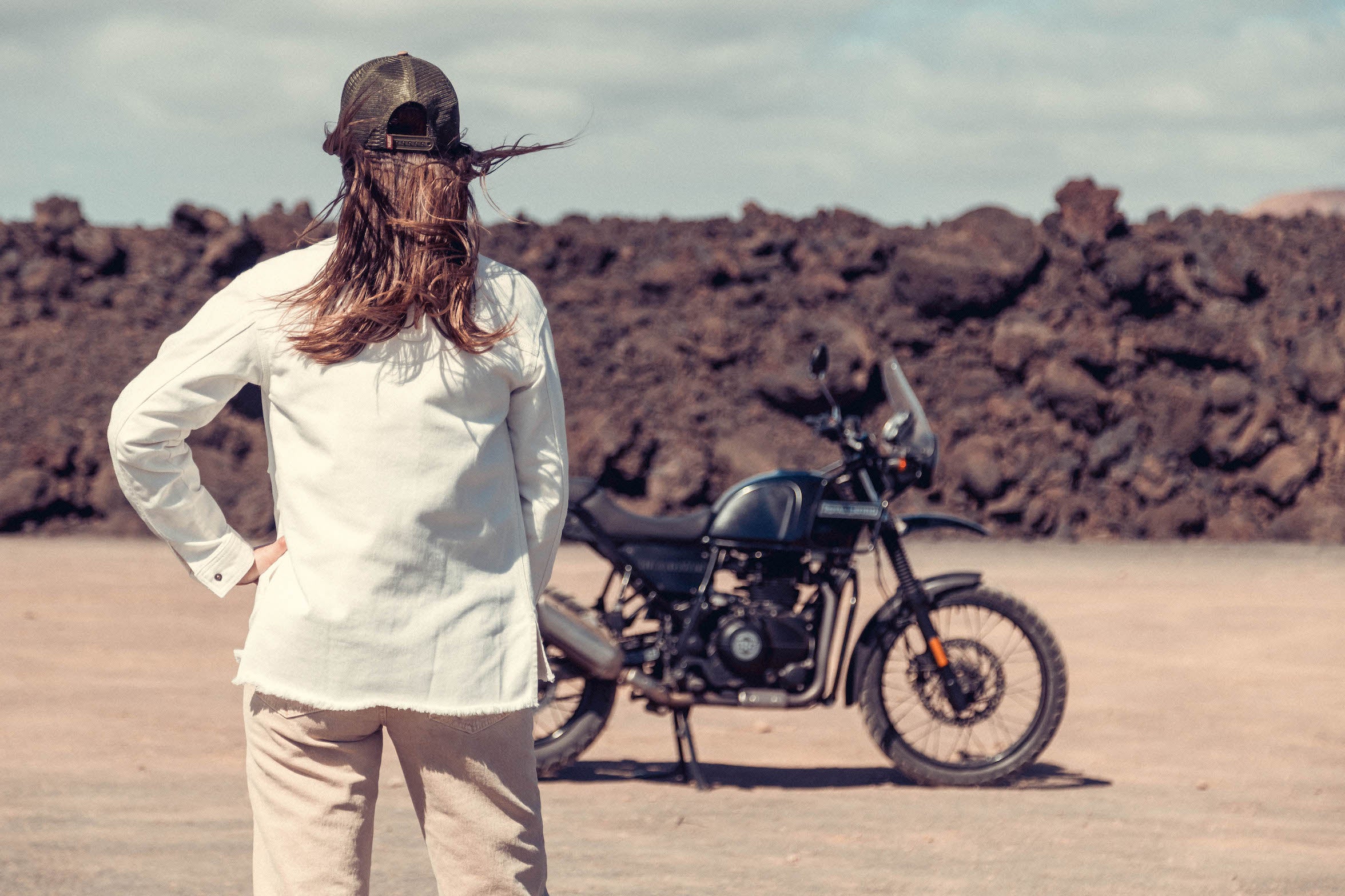 a woman by her motorcycle wearing white denim mc shirt