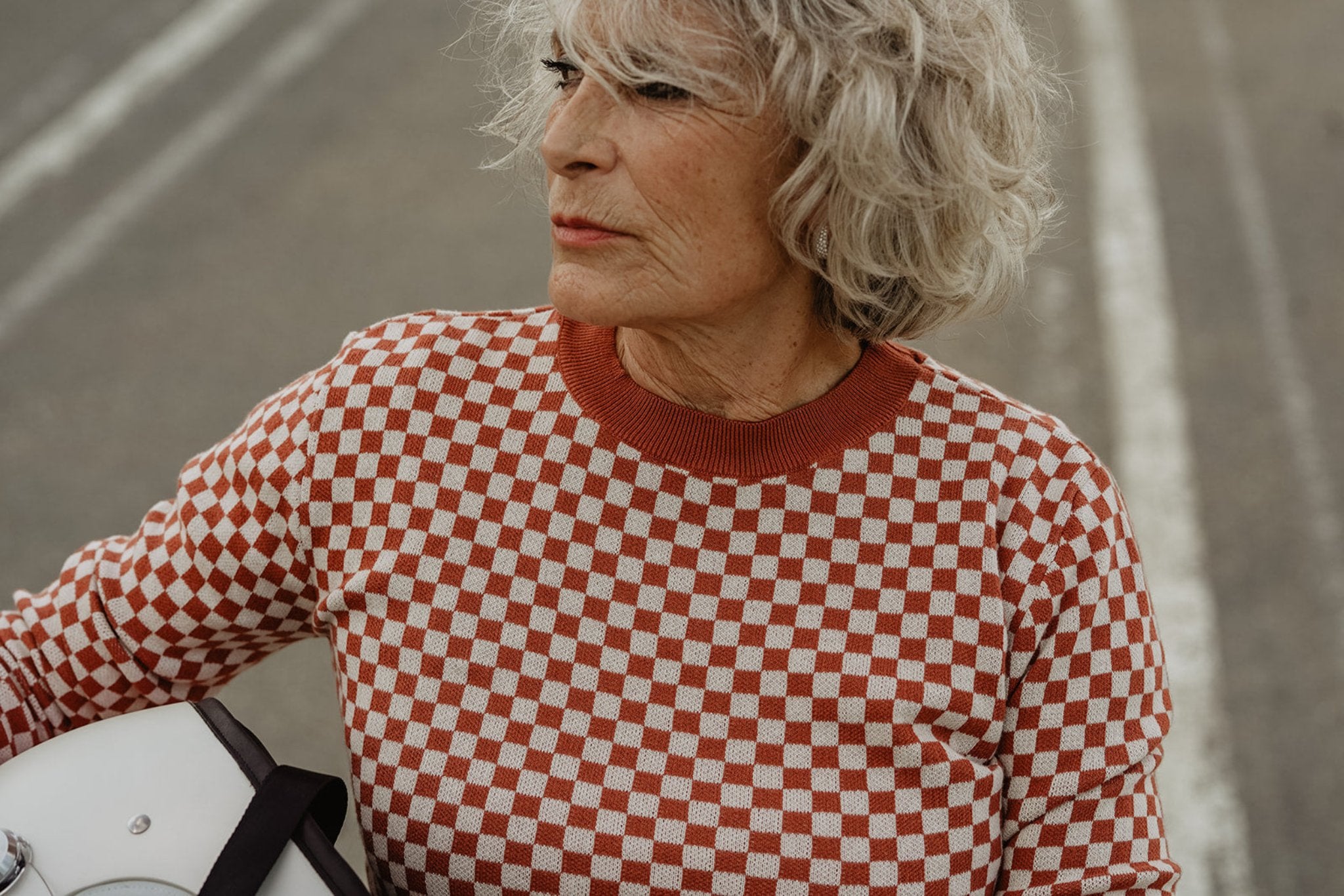 an older lady wearing a knitted red and white jumper with chessboard motives from Wildust