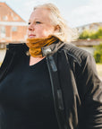 blond woman standing outside while wearing sherrie mc-jacket and a caramel color knitted neck warmer from Moto Girl. 