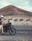 a woman standing by her motorcycle wearing brown khaki denim mc shirt