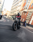 woman motorcyclists in black red leather jacket on her bike riding in London