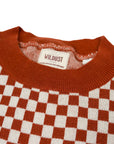 a collar of a knitted red and white jumper with chessboard motives from Wildust