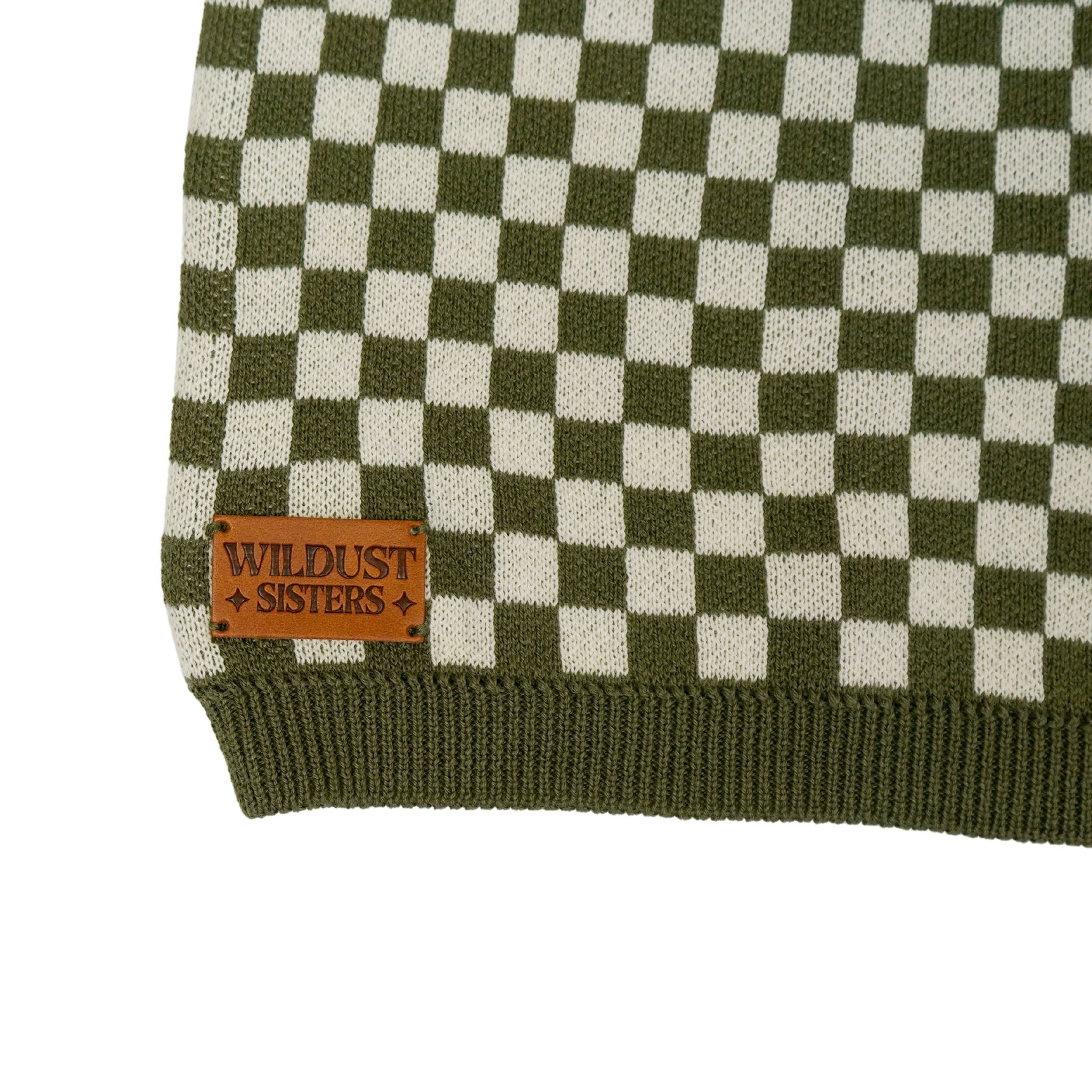 a wildust leather patch on a knitted khaki green and white jumper with chessboard motives  from Wildust