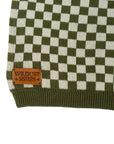 a wildust leather patch on a knitted khaki green and white jumper with chessboard motives  from Wildust