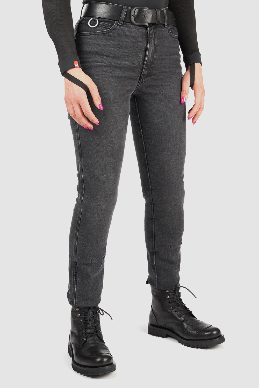 Person wearing black jeans and black boots on a white background