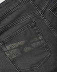 Close-up of a black denim pocket with stitching details