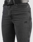 Black jeans with a belt and visible brand logo on a light gray background