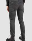 Person wearing black jeans from behind on a light gray background
