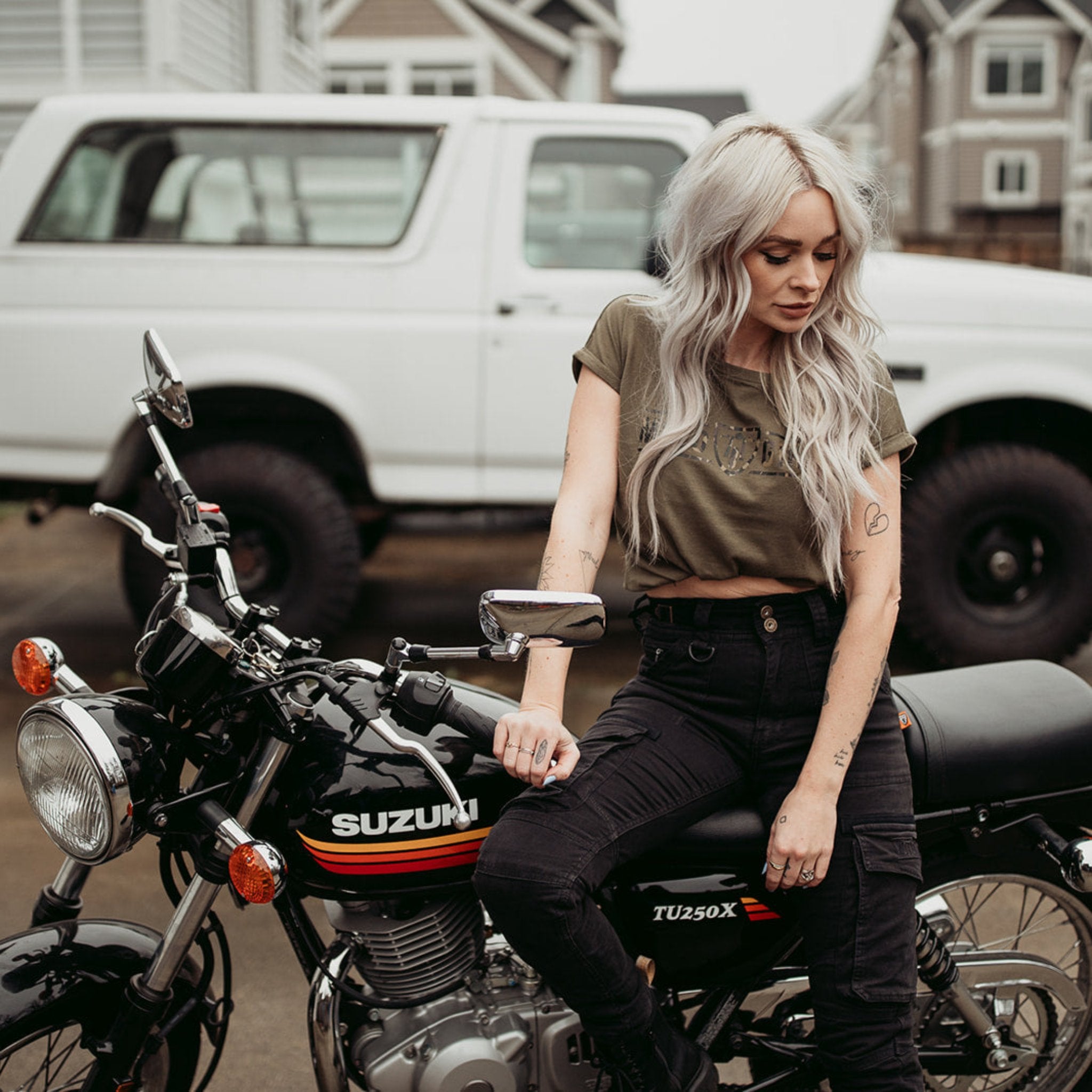 A woman siting on a motorcycle wearing black cargo pants Lara from Moto Girl