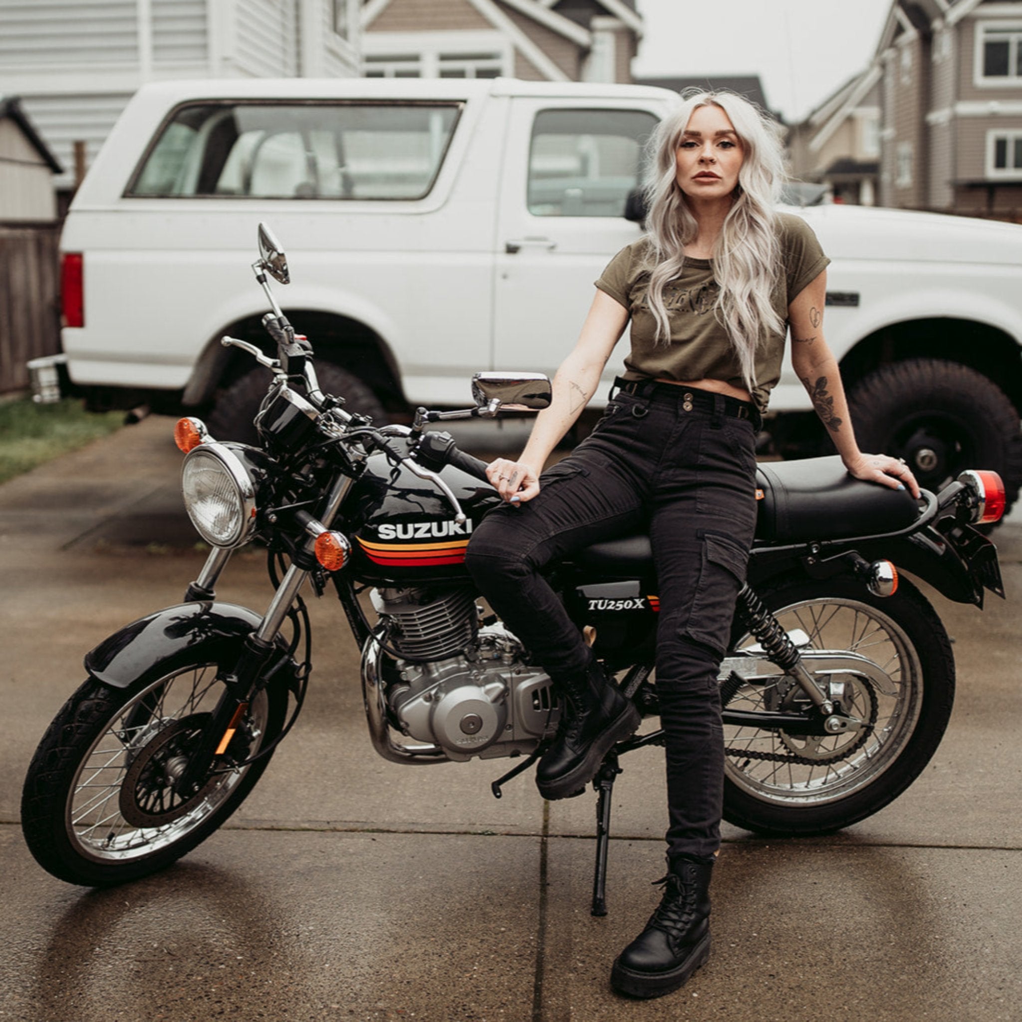 A woman siting on a motorcycle wearing black cargo pants Lara from Moto Girl