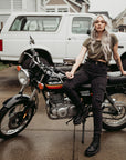 A woman siting on a motorcycle wearing black cargo pants Lara from Moto Girl