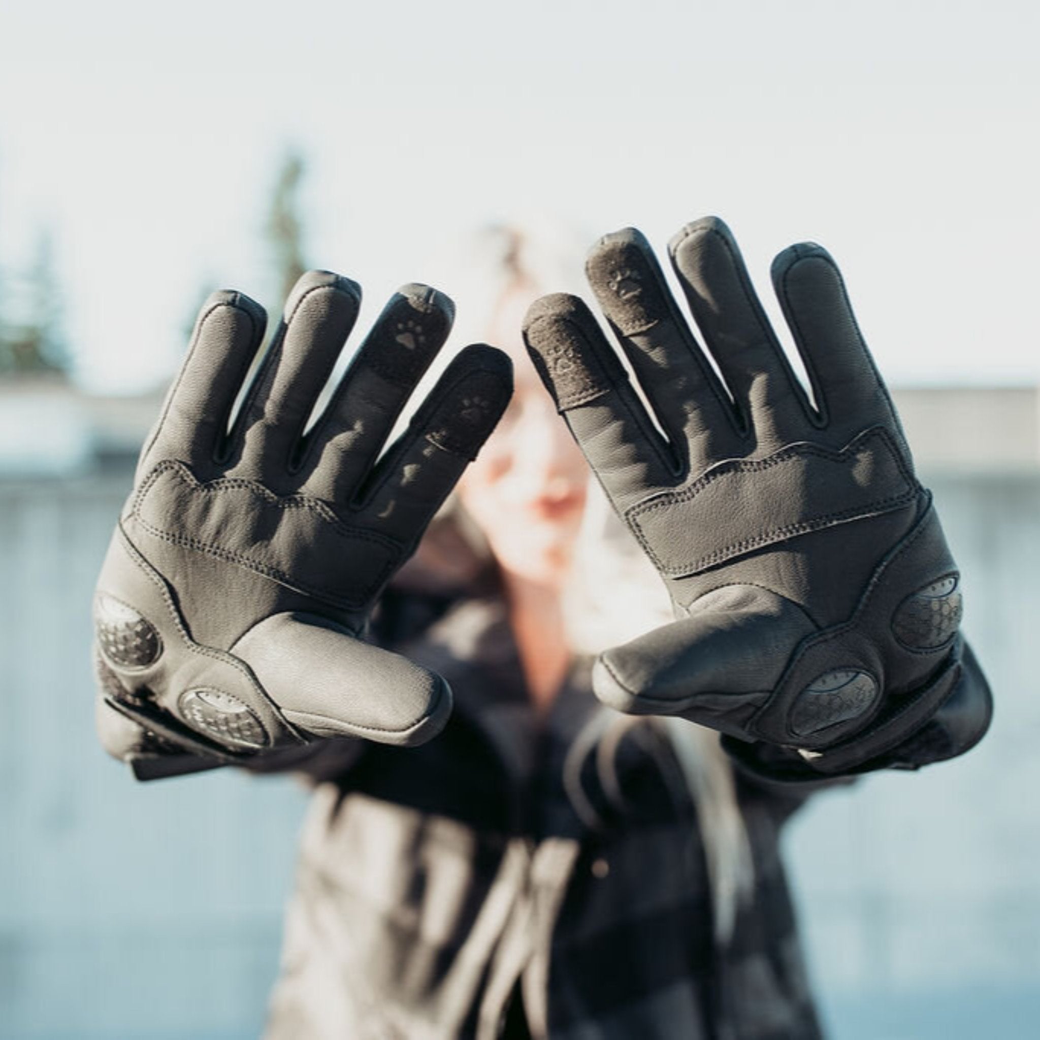 Woman holding up her hands with the Inner side of black Nandi MotoGirl winter motorcycle gloves with paw touch detail on the index and middle fingers and two adjustable velcro fastenings for an optimal fit.