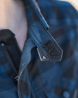 Close-up of a person wearing a blue camouflage jacket with a focus on the shoulder area.