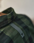 Green plaid shirt with a brand logo on a blurred background