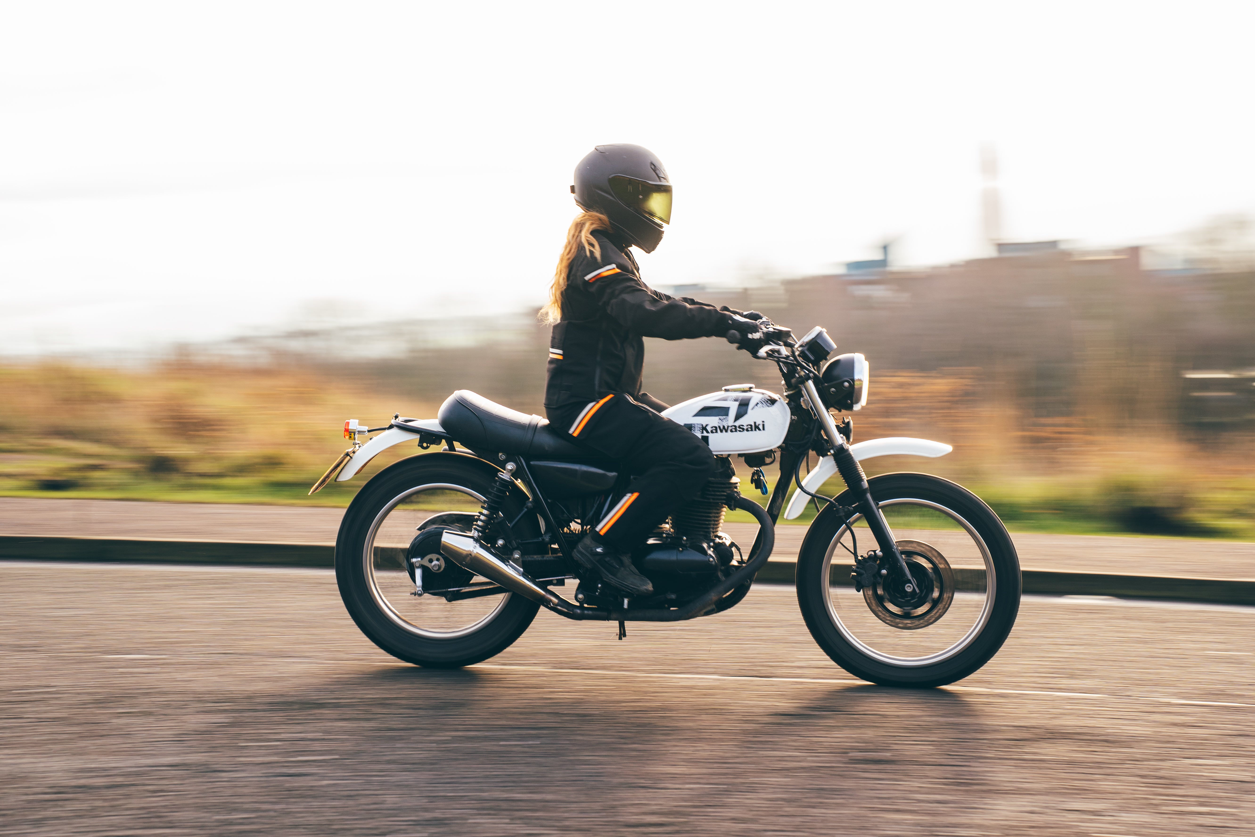 Person riding a motorcycle on a road with a blurred background
