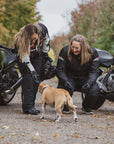 Women motorcyclists greeting a dog 