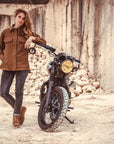 a woman leaning on a motorcycle wearing brown khaki denim mc shirt
