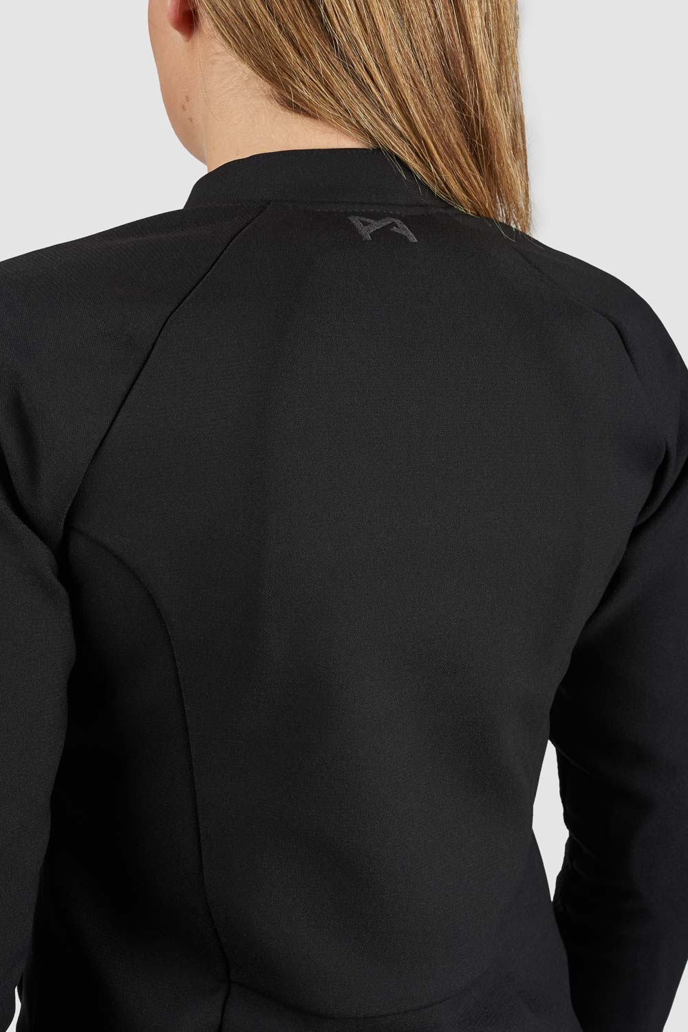 Black blazer with a brand logo on the back, worn by a person.