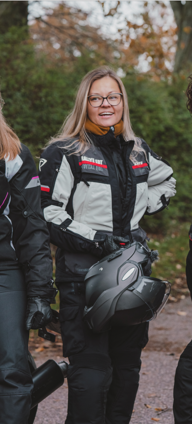 A woman wearing black white and red motorcycle textile jacket 