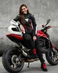 A woman on a motorcycle wearing SHIMA MOTORCYCLE LEATHER jacket IN BLACK FLUO, WHITE AND RED FLUO