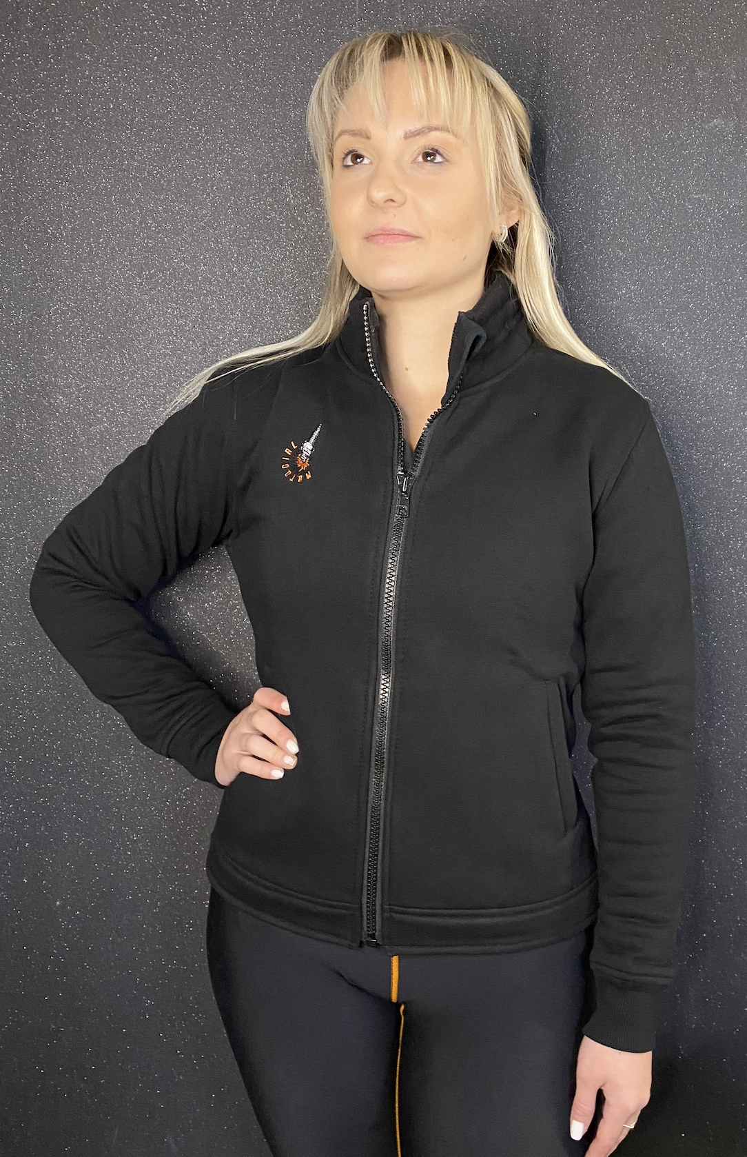 a blond woman wearing black sweatshirt with a zip and MotoGirl embroidery