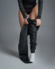 A woman putting her mc pants on wearing Armored motorcycle long-sleeve bodysuit base layer for women