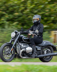 woman driving a motorcycle wearing Black retro style woman's motorcycle jacket with silver zip details