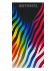 A rectangular beach towel featuring a black top section with the brand name 'MOTOGIRL' in white outlined text, and below it, bold wavy rainbow stripes flowing diagonally across a white background.