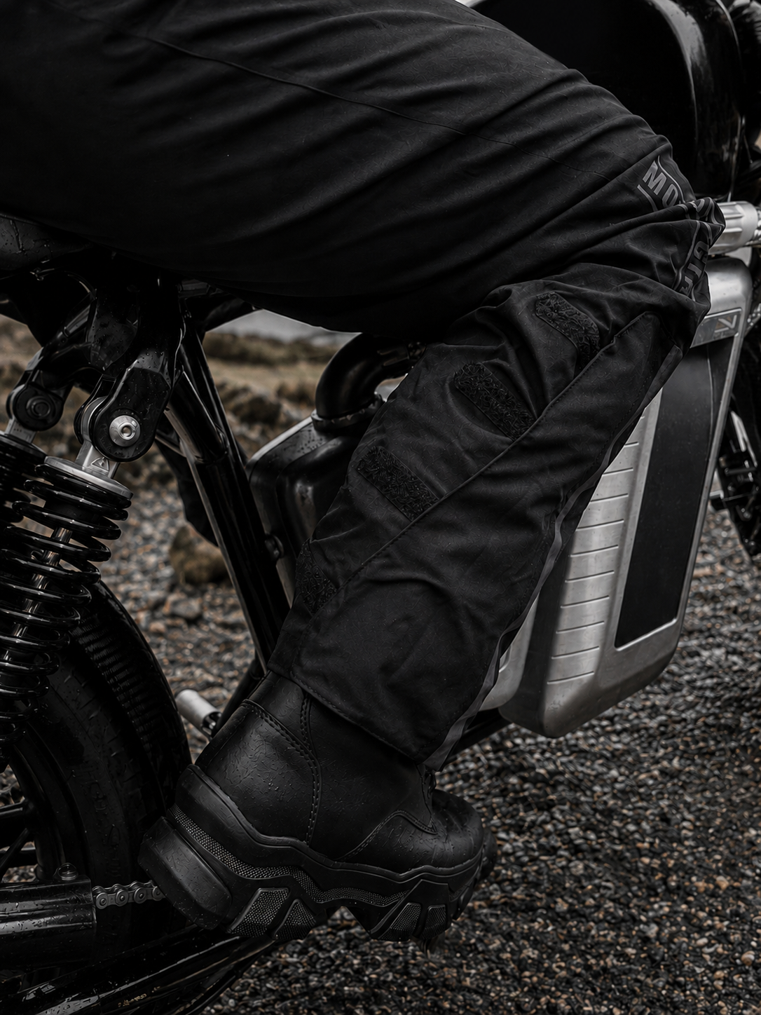 Person wearing black motorcycle boots and pants on a motorcycle.