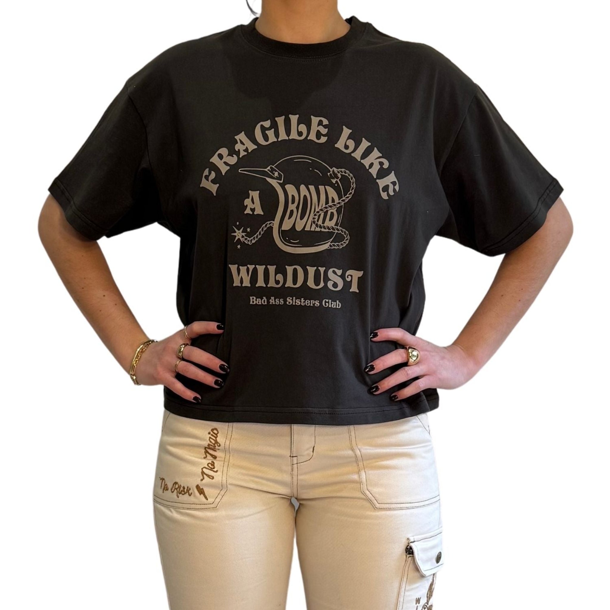 woman demonstarting a off-black wide cut short sleeve women's motorcycle t-shirt with helmet motive and Fragile like a bomb  logo 