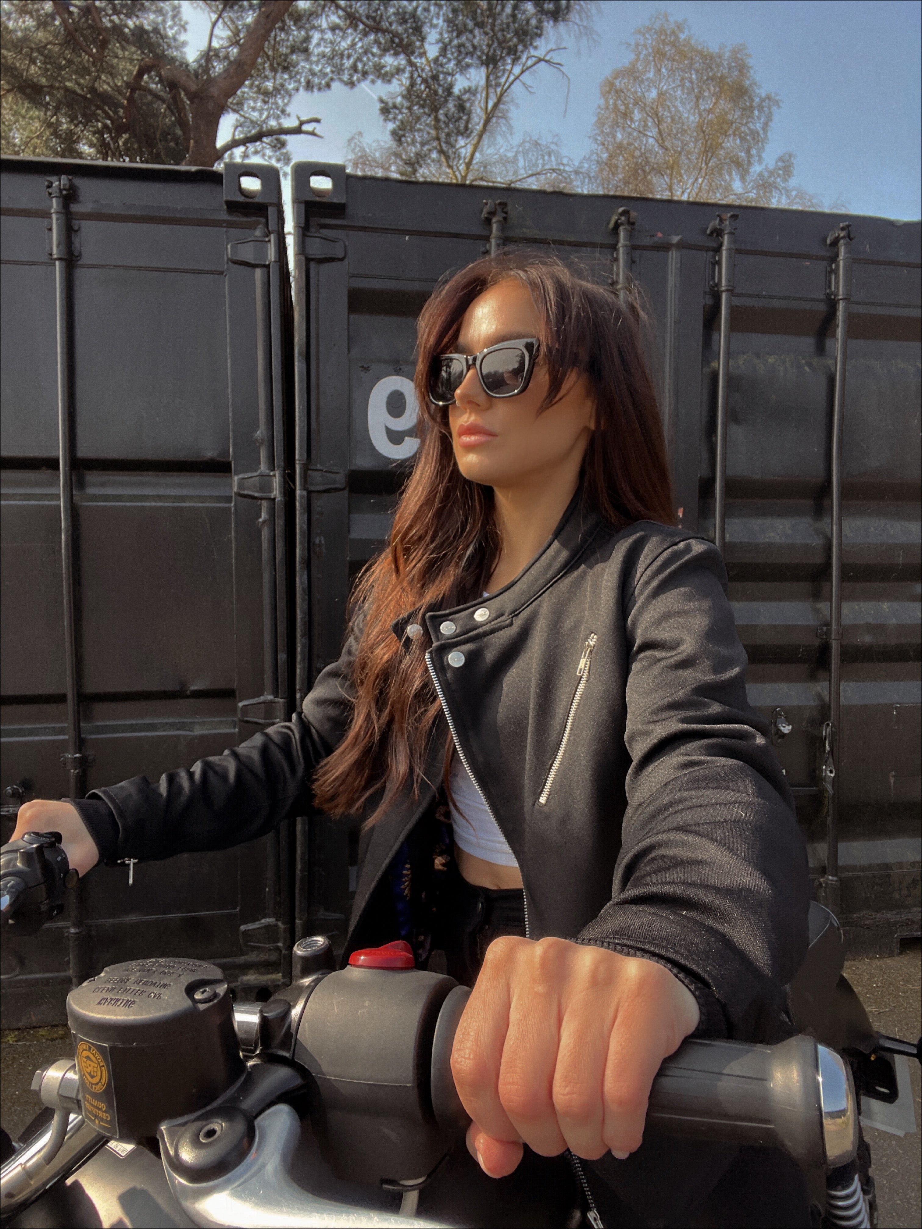 a young lady on a motorcycle wearing Black retro style woman&#39;s motorcycle jacket with silver zip details